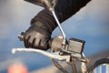 Motorcyclist arm in black glove holds twist grip throttle, close-up view