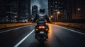 Motorcyclist in a black jacket on a black bike rides along a deserted night road