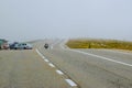 Motorcyclist and cars in fog on the Transalpina road DN67C. This is one of the most beautiful alpine routes in Romania Royalty Free Stock Photo