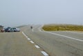 Motorcyclist and cars in fog on the Transalpina road DN67C. This is one of the most beautiful alpine routes in Romania