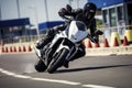 A motorcyclist in full black protective gear and helmet expertly leans into a tight corner on a sportbike at a racing