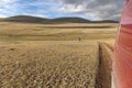 Motorcyclist in a helmet follows the car by motorbike. Mountain Altai, hills of Mongolia