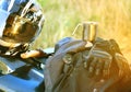 Motorcyclist helmet, gloves, knife, compass and other accessories lie on the seat of a motorcycle.