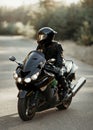 Motorcyclist in a helmet on a motorcycle on a country road. Guy driving a bike during a trip. Riding a modern sports motorcycle on Royalty Free Stock Photo