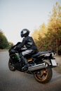 Motorcyclist in a helmet on a motorcycle on a country road. Guy driving a bike during a trip. Riding a modern sports motorcycle on