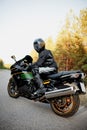 Motorcyclist in a helmet on a motorcycle on a country road. Guy driving a bike during a trip. Riding a modern sports motorcycle on