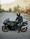 Motorcyclist in a helmet on a motorcycle on a country road. Guy driving a bike during a trip. Riding a modern sports motorcycle on Royalty Free Stock Photo