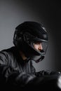 Motorcyclist on his bike wearing helmet riding motorcycle indoors.