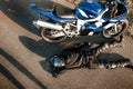 Motorcyclist in leather protective suit and a black helmet lies on the asphalt near a sports motorcycle. Biker in black on the Royalty Free Stock Photo