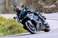 motorcyclist riding on his motorcycle on the road taking a sharp curve Royalty Free Stock Photo