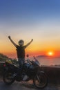 Motorcyclist man enjoy beautiful sunset arms spread out to the sides, sea and mountains. Destination. Motorcycle tour journey. Royalty Free Stock Photo