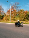 Motorcyclist in motion. Biker on a black motorcycle in traffic on a rural autumn road Royalty Free Stock Photo