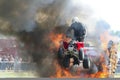 A motorcyclist on a quad bike jumping through fire