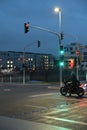 Motorcyclist with retro motorcycle standing in front of a green traffic light in Heerdt