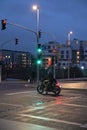 Motorcyclist with retro motorcycle standing in front of a green traffic light in Heerdt