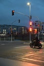 Motorcyclist with retro motorcycle standing in front of a green traffic light in Heerdt