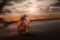 Motorbike drives fast on the road in the evening glow