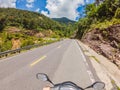 Motorcyclist rides on a serpentine road in cloudy weather. Vietnam, Dalat