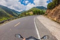 Motorcyclist rides on a serpentine road in cloudy weather. Vietnam, Dalat