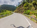 Motorcyclist rides on a serpentine road in cloudy weather. Vietnam, Dalat