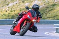 motorcyclist riding on his motorcycle on the road taking a sharp curve Royalty Free Stock Photo