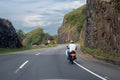 Motorcyclist on a road between mountain slope. Colombia.