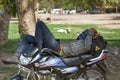 motorcyclist sleeping on a motorcycle in a city Park
