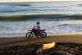 Motorcyclist speeding along waterline on CAstlecliff beach at dusk