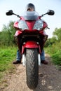 Motorcyclist standing on country road, closeup