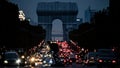 Motorcyclist standing in front of the Arc de Triomphe