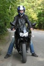 Motorcyclist standing on road