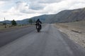 Motorcyclist is traveling by motorcycle on a winding mountain road in summer Royalty Free Stock Photo