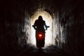 motorcyclist in the tunnel. silhouette of a man riding towards the light through tunnel