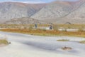 A motorcyclist is waiting for his friend to help transport motorbikes across a mountain river, Altai Mongolia