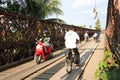 Motorcyclists and Cyclists crossing old bridge across Mekong River