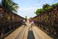 Motorcyclists and Cyclists crossing old bridge across Mekong River