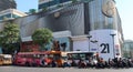 Motorcyclists and public buses stop at a traffic light