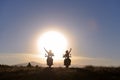 Motorcyclists waving at sun