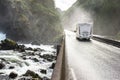 Motorhome Camper Van driving fast on wet canyon valley road and bridge across waterfall river. Norway. Royalty Free Stock Photo