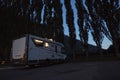 Motorhome camper vehicle for transport and vacation leisure people parked by night near a forest woods enjoying outdoors in travel Royalty Free Stock Photo