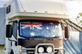 Motorhome campervan with flag of Australia on the windscreen at the campground. Australian camping and travel lifestyle concept