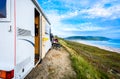 Motorhome RV and campervan are parked on a beach