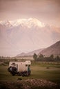 Motorhome and a sidecar motorcycle backed by a snowy mountain range