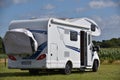 Motorhome standing on grass and near a cornfield