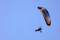 Motorized paraglider flying in the blue sky