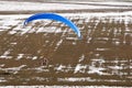 Motorized paraglider or paramotor preparing to land on a light aircraft runway for ULM in winter under the snow Royalty Free Stock Photo