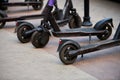 Motorized scooter parking for hourly rent on sidewalk street, vehicle for fast movement around town