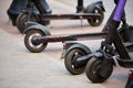 Motorized scooter parking for hourly rent on sidewalk street, vehicle for fast movement around town