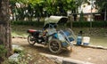 Motorized tricycles parks beside a dirty river photo taken in Semarang Indonesia
