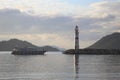 The Motoryacht returns to the marina at sunset. The lighthouse guides the boat. Royalty Free Stock Photo